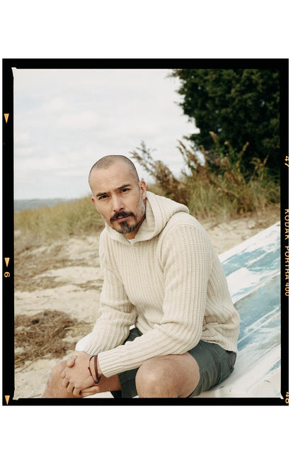 fit model sitting wearing The Bryan Sweater in Flax Melange