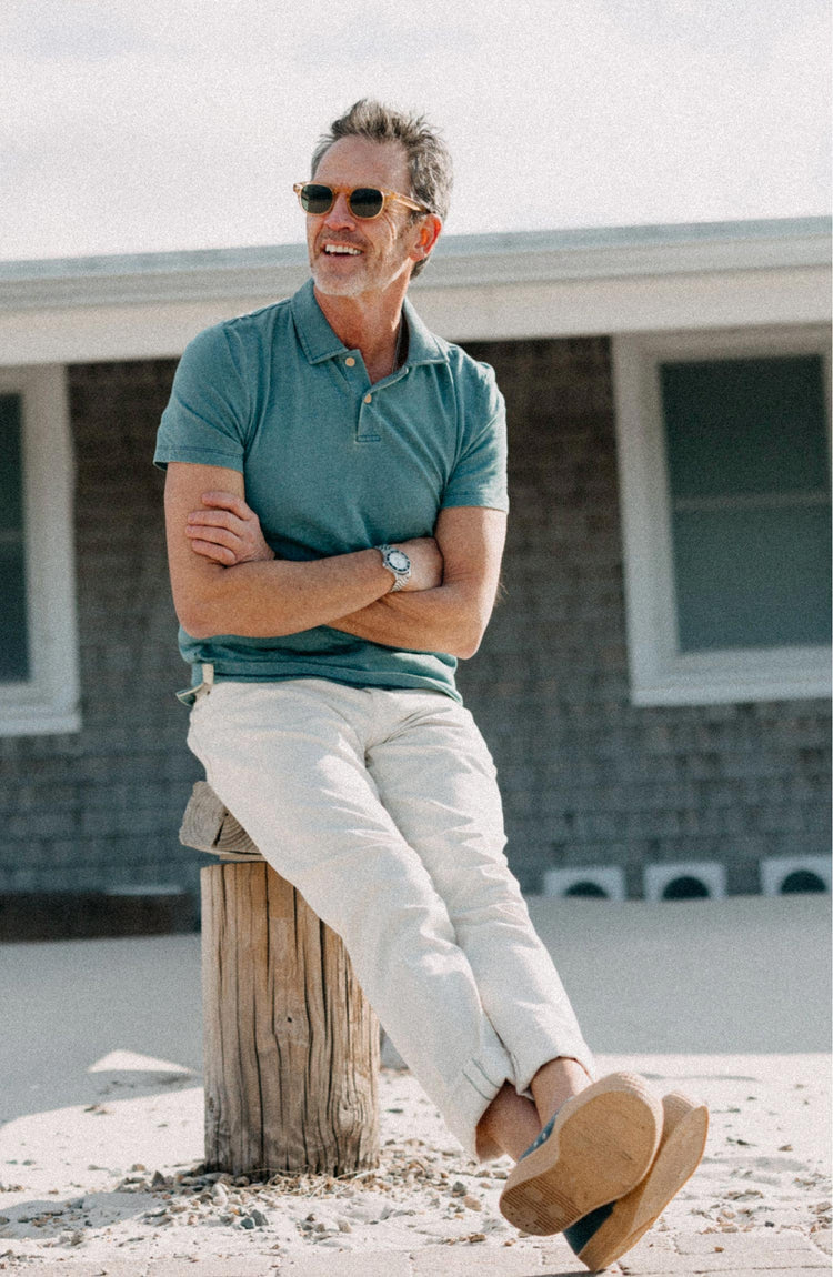 fit model sitting wearing The Organic Cotton Polo in Washed Indigo