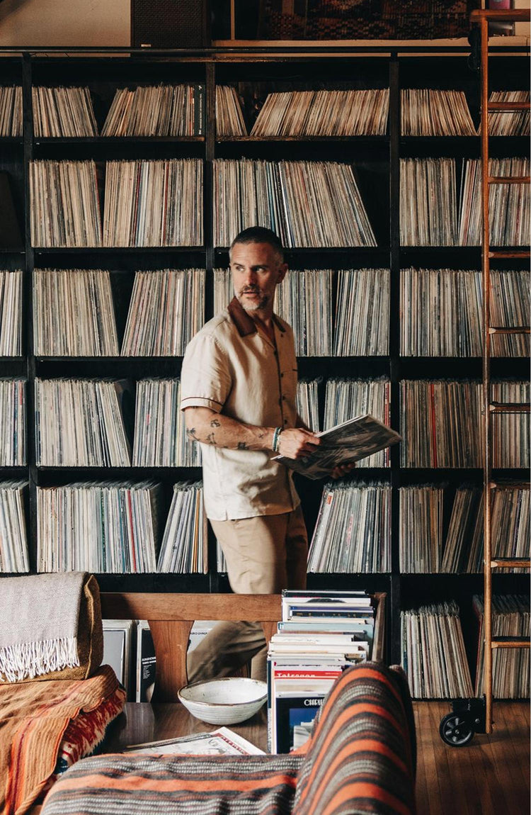 fit model holding a record wearing The Palmer Shirt in Dune