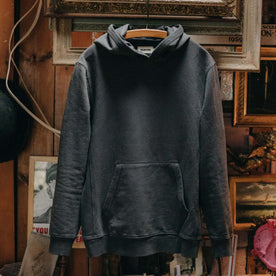 The Cotton Hemp Hoodie in Asphalt hanging in a studio