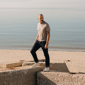 fit model standing on a rock wearing The Cotton Hemp Tee in Steeple Grey