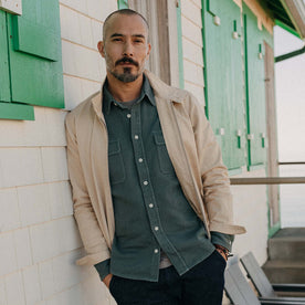 fit model leaning against the wall wearing The Flint Jacket in Light Khaki Broken Twill