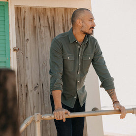 fit model leaning on a pole wearing The Ledge Shirt in Deep Sea Twill