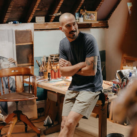 fit model sitting on a desk for The Merino Tee in Heather Navy