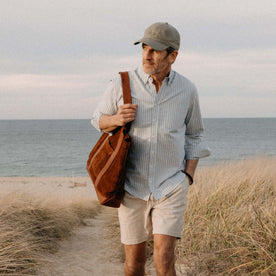 fit model walking on the beach with The Roughout Tote in Chocolate Suede