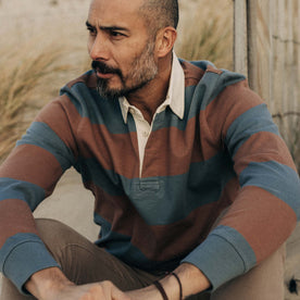 fit model sitting wearing The Rugby Shirt in Faded Brick Stripe