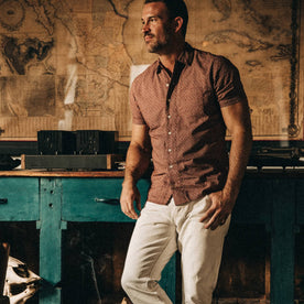 fit model wearing The Short Sleeve Hawthorne in Burgundy Trellis, standing near map of mexico