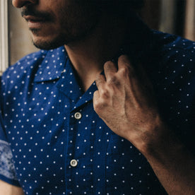 fit model adjusting the camp collar on The Short Sleeve Hawthorne in Indigo Star Dot Border