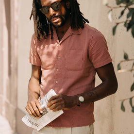 fit model holding a newspaper wearing The Conrad Shirt in Fired Brick Dobby