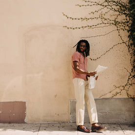 fit model leaning against the wall wearing The Conrad Shirt in Fired Brick Dobby