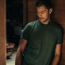 fit model leaning against the wall wearing The Cotton Hemp Tee in Pine