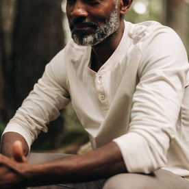 fit model sitting wearing The Heavy Bag Henley in Natural