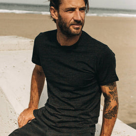 fit model sitting wearing The Merino Tee in Heather Black