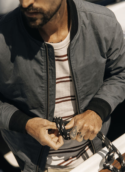 Model tying a sailing knot in the Colton Crew and The Bomber Jacket in Charcoal Dry Wax