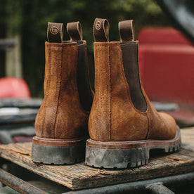 material shot outdoors of fit model wearing The Ranch Boot in Redwood Waxed Suede, back heel